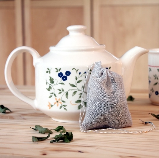filtre à thé en tissus de lin devant une théière